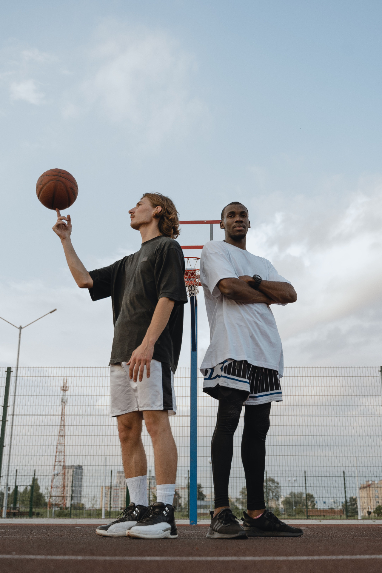 Two mates on an outdoor basketball court