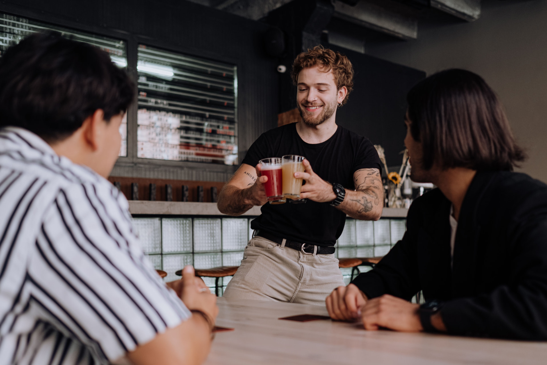 Bartender serving drinks to mates at a Melbourne bar