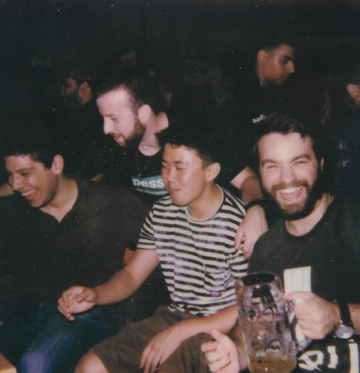 A group of mates laughing together over beers at a pub